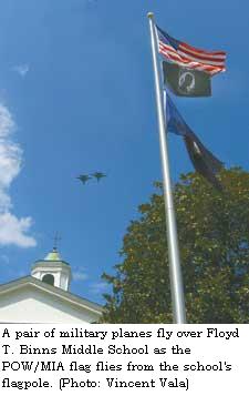 A pair of military planes fly over Floyd T. Binns Middle School as the POW/MIA flag flies from the school's flagpole. (Staff Photo, Vincent Vala)